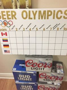 the beer olympics board is next to several boxes of beer on the floor in front of a wall