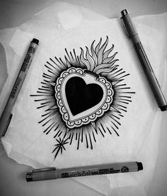 a drawing of a heart on paper with two crayons next to it