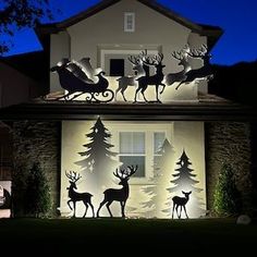 a house decorated with christmas lights and reindeer silhouettes