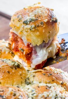 a close up of a piece of bread with cheese and sauce on it, being held by a spatula