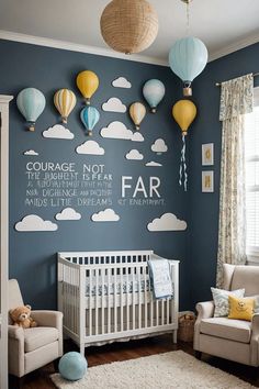 a baby's room with blue walls and hot air balloons on the wall above it