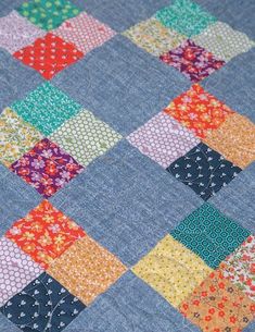 a blue quilt with multicolored squares on it