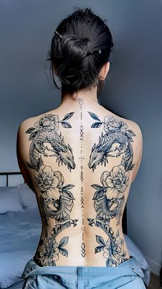 the back of a woman's body with tattoos on her upper and lower back