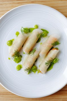 some food is on a white plate with green garnishes and sauces