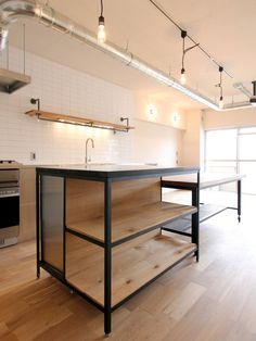 an empty kitchen with wooden floors and stainless steel appliances