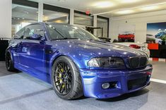 a blue car is parked in a showroom