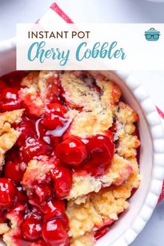 a white bowl filled with cherry cobbler on top of a table