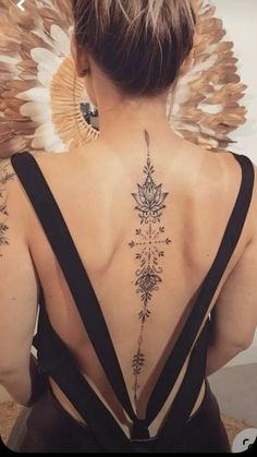 the back of a woman's neck with feathers on it