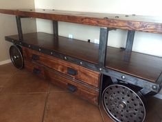 a large wooden shelf with metal wheels on it's sides in a living room