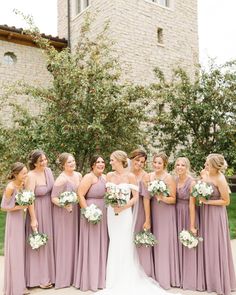 a group of bridesmaids standing in front of a church