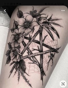 a woman's thigh with flowers on it and a cross in the middle,