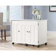 a white cabinet sitting on top of a hard wood floor