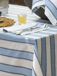 a blue and white striped table cloth on a dining room table with utensils