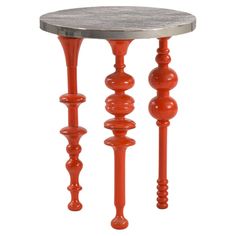 an orange table with three legs and a marble top