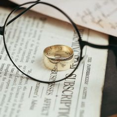 a pair of glasses sitting on top of a piece of paper next to a ring