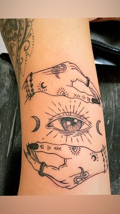 an artistic tattoo on the leg of a woman with all seeing eyes and moon hands