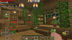 the inside of a minecraft house with plants and flowers on the floor, lights hanging from the ceiling