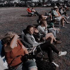 several people sitting in lawn chairs and one person is covering his face with her hand