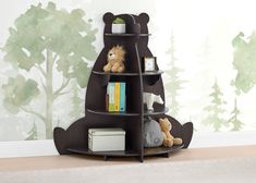 a teddy bear shelf with books and stuffed animals on it in front of a wall mural