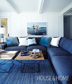 a living room with blue couches and pillows on top of the sofa is an art piece