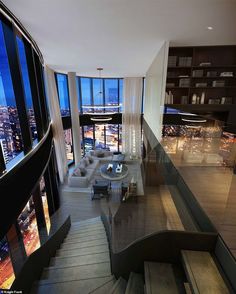 an image of a staircase in the middle of a living room with large windows and city view