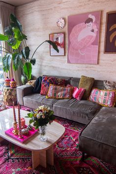 a living room filled with lots of furniture next to a tall plant in a vase