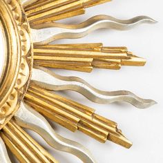 an ornate gold and silver clock on a white background with lots of small holes in it