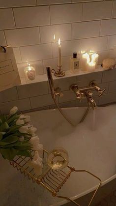 a bathtub with candles and flowers in it