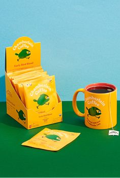 a yellow coffee mug sitting on top of a green table