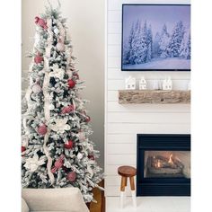 a decorated christmas tree in front of a fireplace