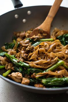 stir fried noodles with mushrooms and spinach in a pan