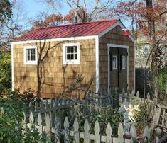 a small wooden shed sitting next to a fence