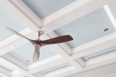 a ceiling fan mounted to the ceiling in a room with blue walls and white ceilings