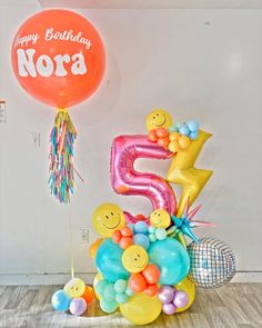 a number five balloon surrounded by balloons and streamers