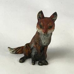 a small figurine of a fox on a white background