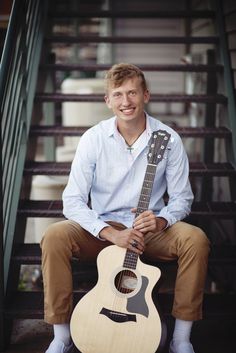 a man sitting on some steps holding a guitar