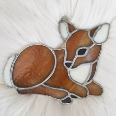 a brooch that is sitting on top of a fur covered surface with an animal in the center