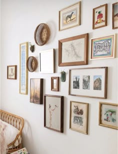 a wall with many framed pictures on it