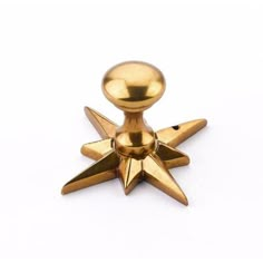 a gold colored metal object with spikes on it's back end and one pointed at the top