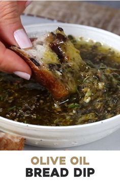 someone dipping bread into a bowl of olive oil bread dip with the words olive oil bread dip above it