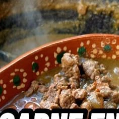 a bowl filled with meat and broth sitting on top of a table