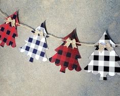 paper christmas trees are hung on a rope with gingham checkered fabric and bows