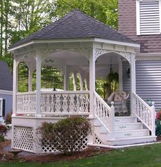 a white gazebo sitting on top of a lush green field