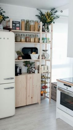 a white refrigerator freezer sitting inside of a kitchen next to a stove top oven