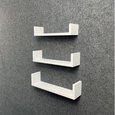 two white shelfs on the wall in an office