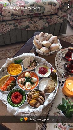 a table topped with lots of food on top of a wooden table next to a couch