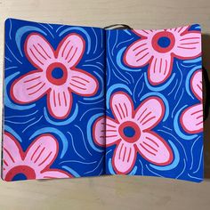 an open notebook with pink and blue flowers on it