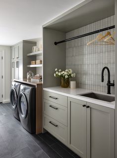 a washer and dryer in a kitchen with white cabinets