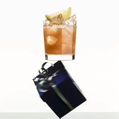 an image of a drink being served in a glass with a gift box on the table