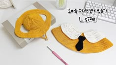 a crocheted hat and purse sitting on top of a desk next to a keyboard